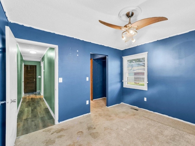 1045 Briarcliff Dr, Rantoul, IL 61866 - unfurnished bedroom with carpet, a textured ceiling, baseboards, and a ceiling fan