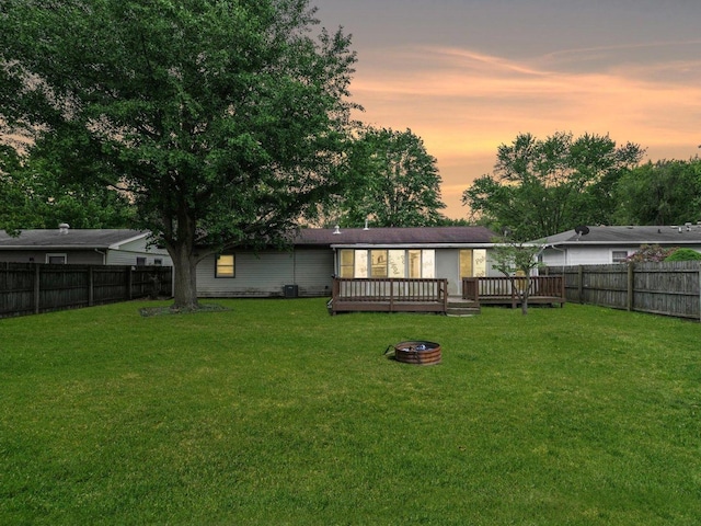 1045 Briarcliff Dr, Rantoul, IL 61866 - back of property featuring a wooden deck, central AC, and an outdoor fire pit