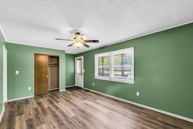 1045 Briarcliff Dr, Rantoul, IL 61866 - unfurnished bedroom featuring wood finished floors, a textured ceiling, a closet, baseboards, and a ceiling fan