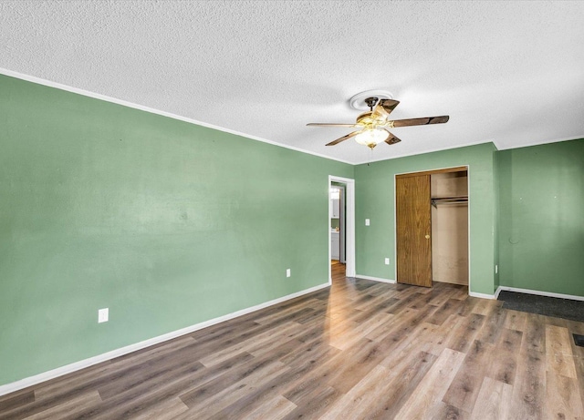 1045 Briarcliff Dr, Rantoul, IL 61866 - unfurnished bedroom with a textured ceiling, wood finished floors, baseboards, a closet, and ceiling fan
