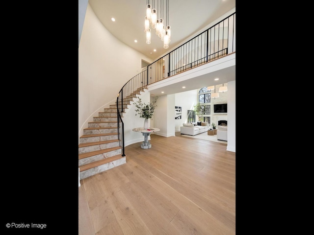 interior space featuring recessed lighting, wood finished floors, baseboards, and stairs