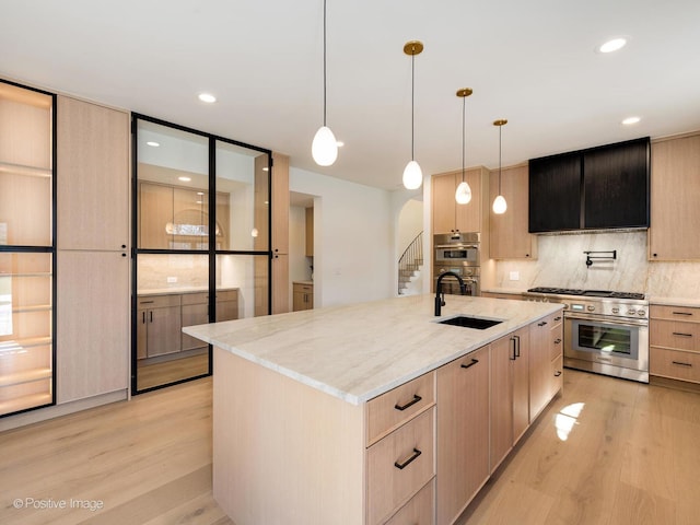 kitchen with light wood finished floors, appliances with stainless steel finishes, and light brown cabinets