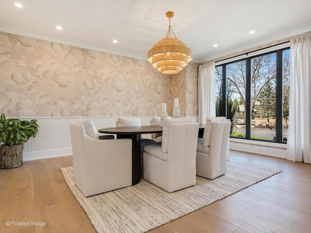 unfurnished dining area featuring wallpapered walls, a notable chandelier, and crown molding