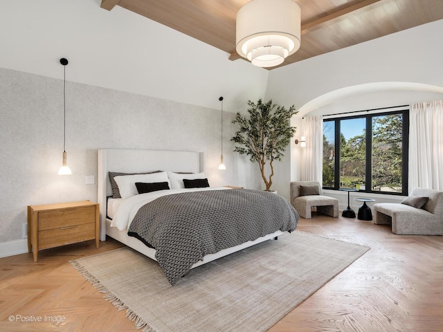 bedroom featuring baseboards and arched walkways