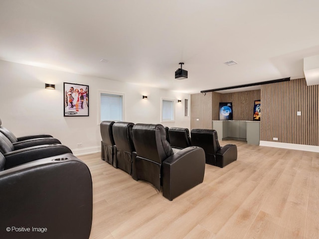 home theater room with light wood-style flooring and baseboards