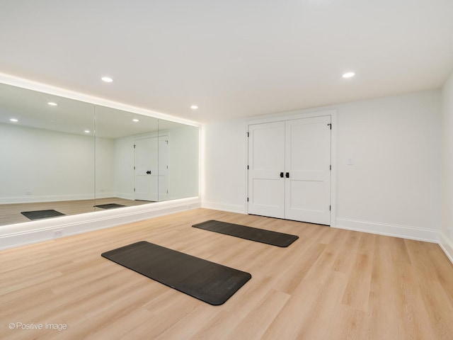 workout area featuring baseboards, wood finished floors, and recessed lighting