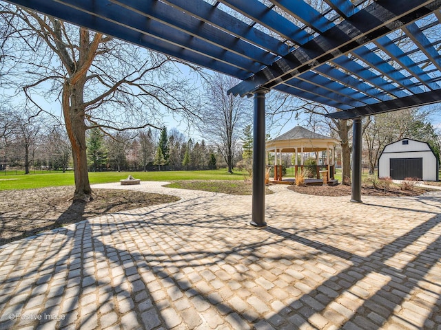 view of patio / terrace with a gazebo, a storage unit, an outbuilding, and a pergola