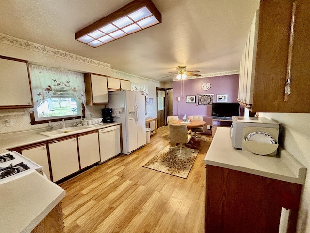 2445 Graham Rd, Belvidere, IL 61008 - kitchen with light countertops, a sink, white appliances, light wood-type flooring, and white cabinetry