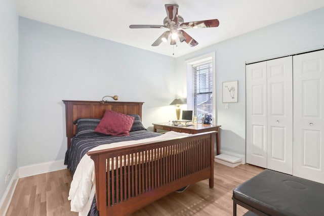 bedroom with a closet, light wood finished floors, a ceiling fan, and baseboards