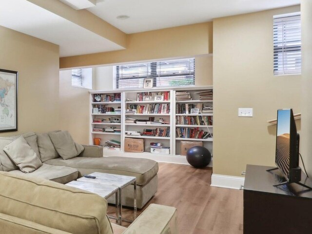 bedroom with a closet, light wood finished floors, a ceiling fan, and baseboards