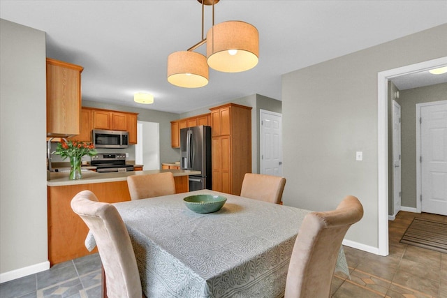dining space with baseboards and light tile patterned floors