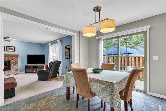dining space with carpet flooring, baseboards, tile patterned flooring, and a fireplace