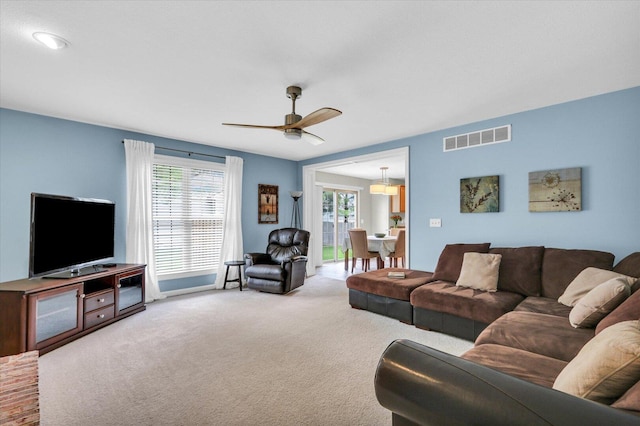 carpeted living area featuring ceiling fan and visible vents