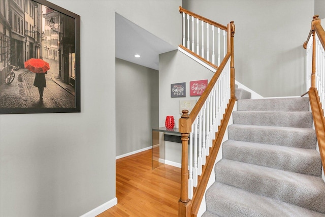 stairway with baseboards, recessed lighting, and wood finished floors