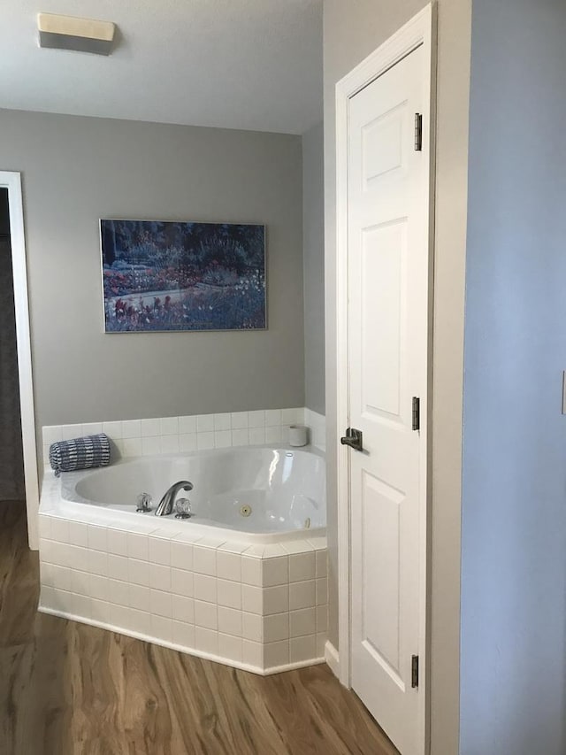 bathroom featuring a jetted tub and wood finished floors