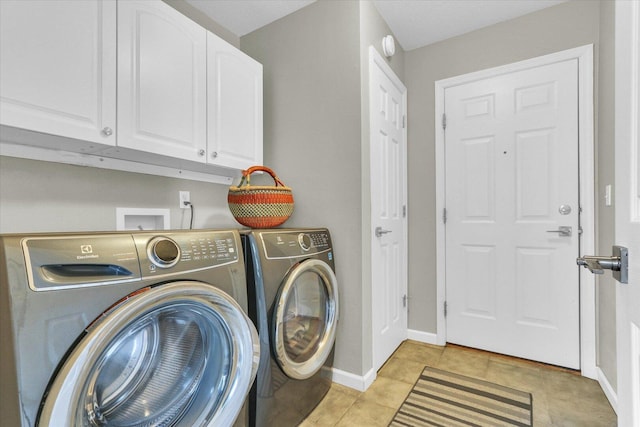 laundry area featuring cabinet space, light tile patterned flooring, baseboards, and washing machine and dryer