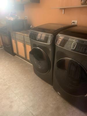 washroom featuring washing machine and clothes dryer and cabinet space