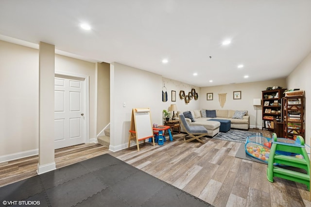 living room featuring recessed lighting, wood finished floors, and stairway