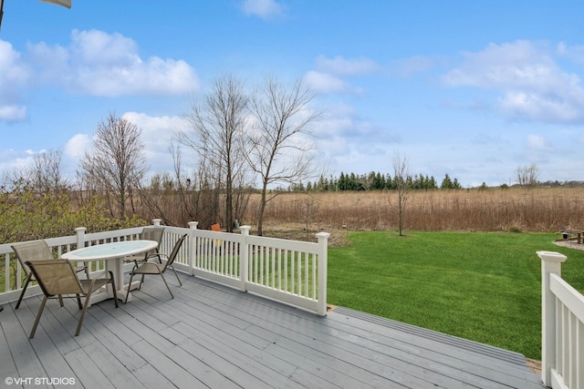 wooden deck featuring a lawn and outdoor dining space