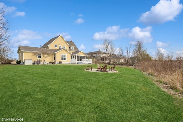 exterior space featuring a fire pit, a sunroom, a chimney, and a lawn