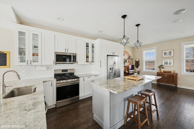 kitchen featuring dark wood-style floors, a sink, appliances with stainless steel finishes, and tasteful backsplash
