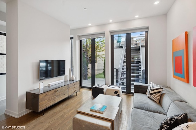 living room with recessed lighting, baseboards, and wood finished floors