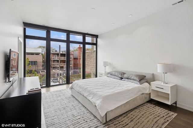 bedroom with baseboards, dark wood-style floors, and visible vents