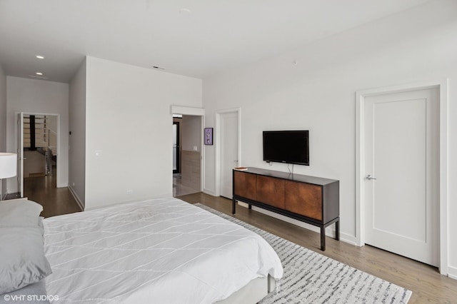 bedroom with visible vents, wood finished floors, baseboards, and recessed lighting