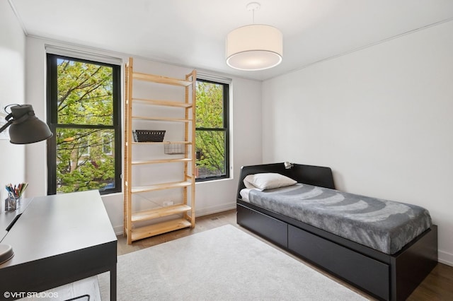 bedroom with baseboards and wood finished floors