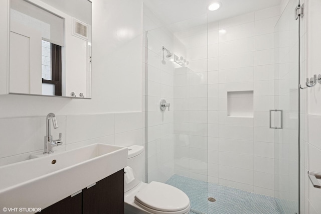 bathroom with a stall shower, tile walls, recessed lighting, toilet, and visible vents