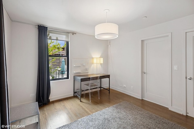 interior space featuring baseboards and wood finished floors