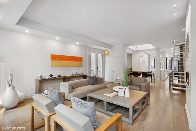 living room featuring light wood finished floors, a chandelier, and recessed lighting