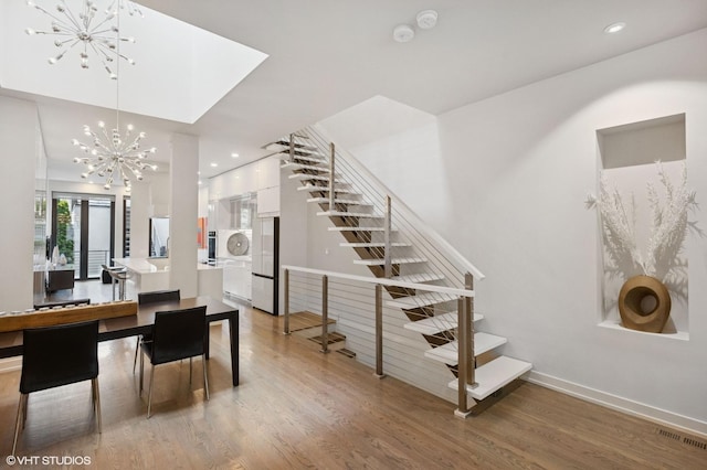 staircase featuring recessed lighting, visible vents, wood finished floors, and a notable chandelier