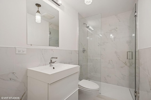 full bath featuring vanity, tile walls, a marble finish shower, and toilet