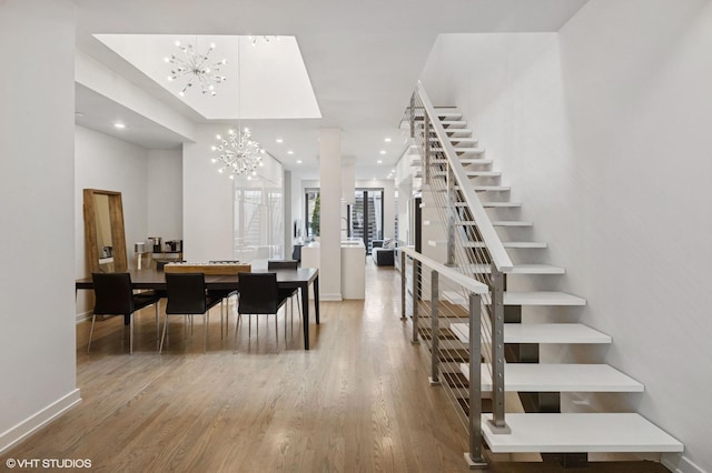 entryway featuring an inviting chandelier, wood finished floors, stairway, baseboards, and recessed lighting