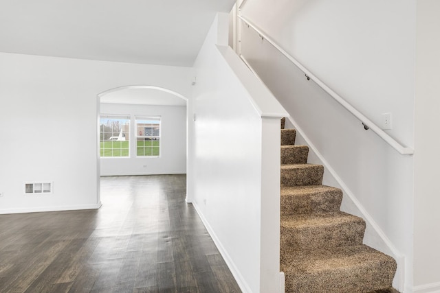 169 Waterbury Cir, Oswego, IL 60543 - staircase with baseboards, wood finished floors, visible vents, and arched walkways
