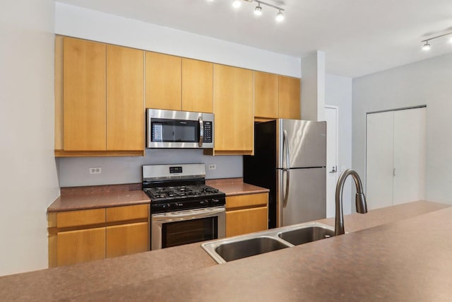 kitchen featuring track lighting, appliances with stainless steel finishes, and a sink