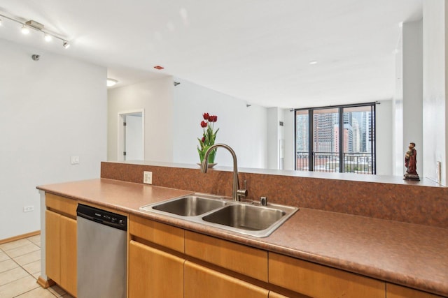kitchen with a sink, light tile patterned floors, and stainless steel dishwasher