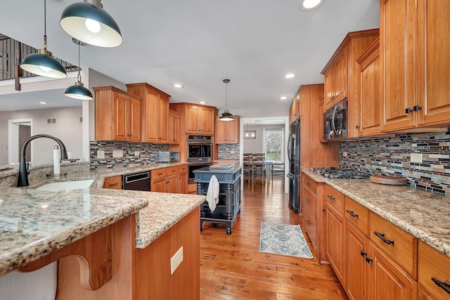 5255 Crescent Green Ct, Morris, IL 60450 - kitchen with light stone counters, a sink, decorative backsplash, light wood-style floors, and appliances with stainless steel finishes