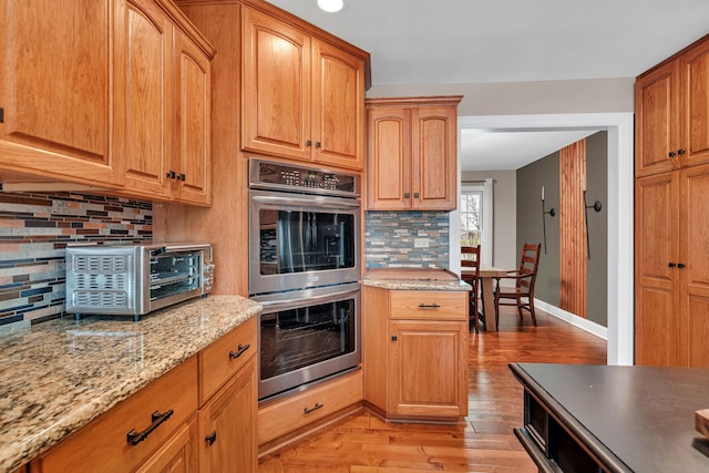 5255 Crescent Green Ct, Morris, IL 60450 - kitchen with a toaster, stainless steel double oven, backsplash, light wood-type flooring, and light stone countertops