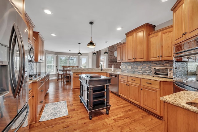 5255 Crescent Green Ct, Morris, IL 60450 - kitchen featuring backsplash, a peninsula, stainless steel appliances, and light wood-style flooring