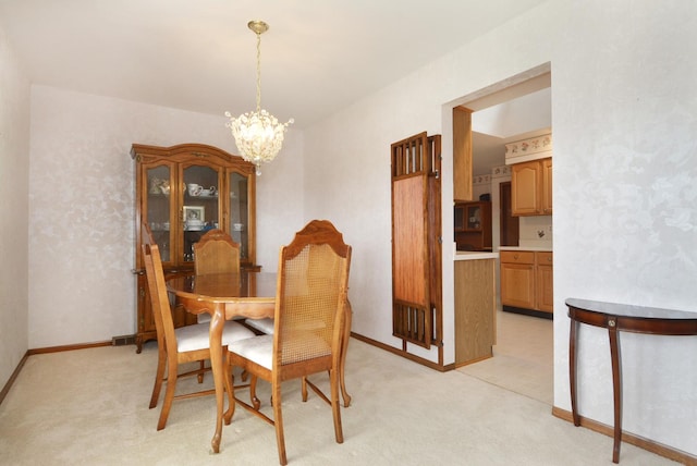 dining area featuring baseboards, a notable chandelier, and light colored carpet