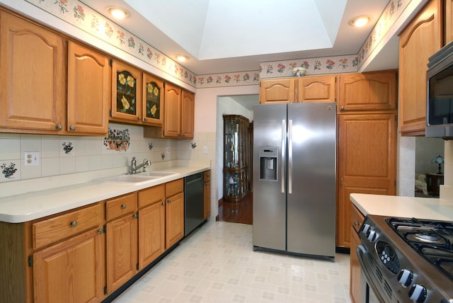 kitchen featuring brown cabinets, appliances with stainless steel finishes, a sink, and light countertops