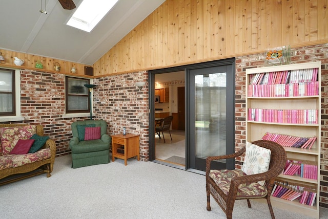 living area featuring wooden walls, lofted ceiling with skylight, brick wall, and carpet