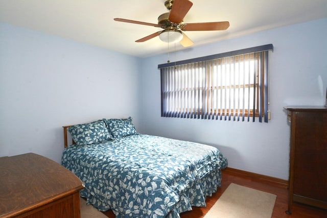 bedroom featuring ceiling fan, baseboards, and wood finished floors