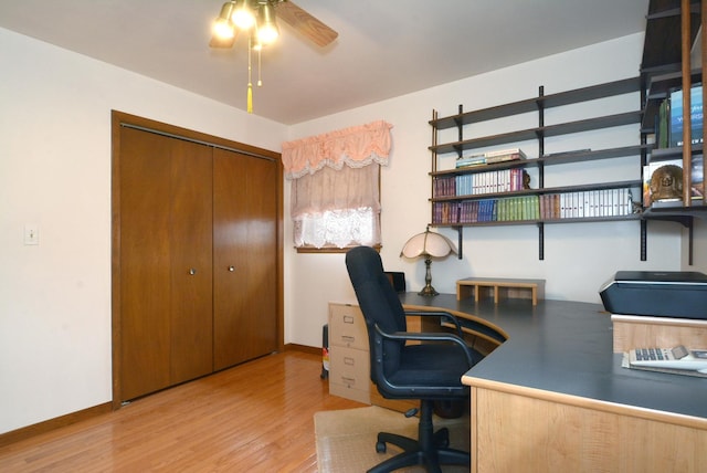 office space with a ceiling fan, baseboards, and light wood-style floors