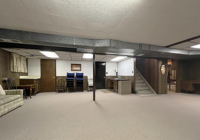 finished below grade area featuring carpet, visible vents, stairs, and a paneled ceiling