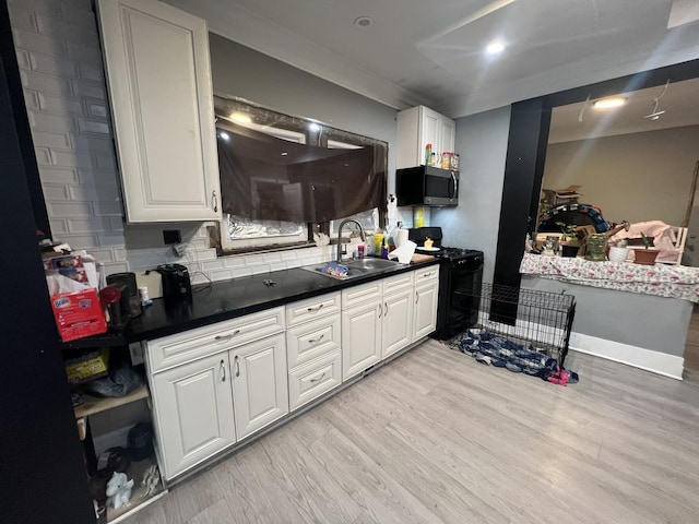 3039 W Flournoy St, Chicago, IL 60612 - kitchen featuring light wood-style flooring, black gas range, a sink, and stainless steel microwave