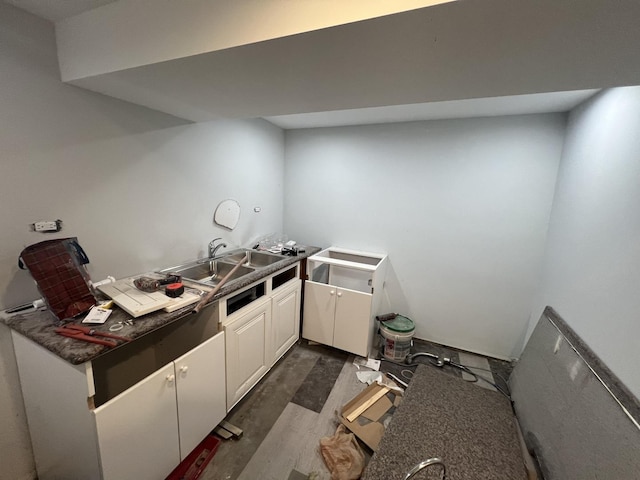 3039 W Flournoy St, Chicago, IL 60612 - kitchen featuring dark countertops, dark wood-style flooring, a sink, and white cabinetry