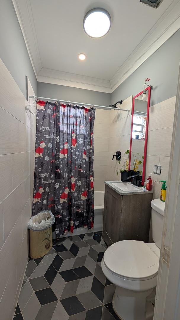 3039 W Flournoy St, Chicago, IL 60612 - bathroom featuring shower / bath combo, toilet, crown molding, and tile walls